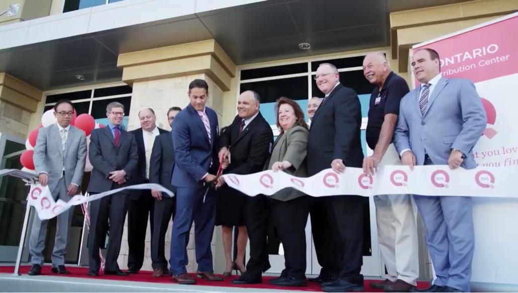 A group of people attend a ribbon-cutting ceremony at a business.